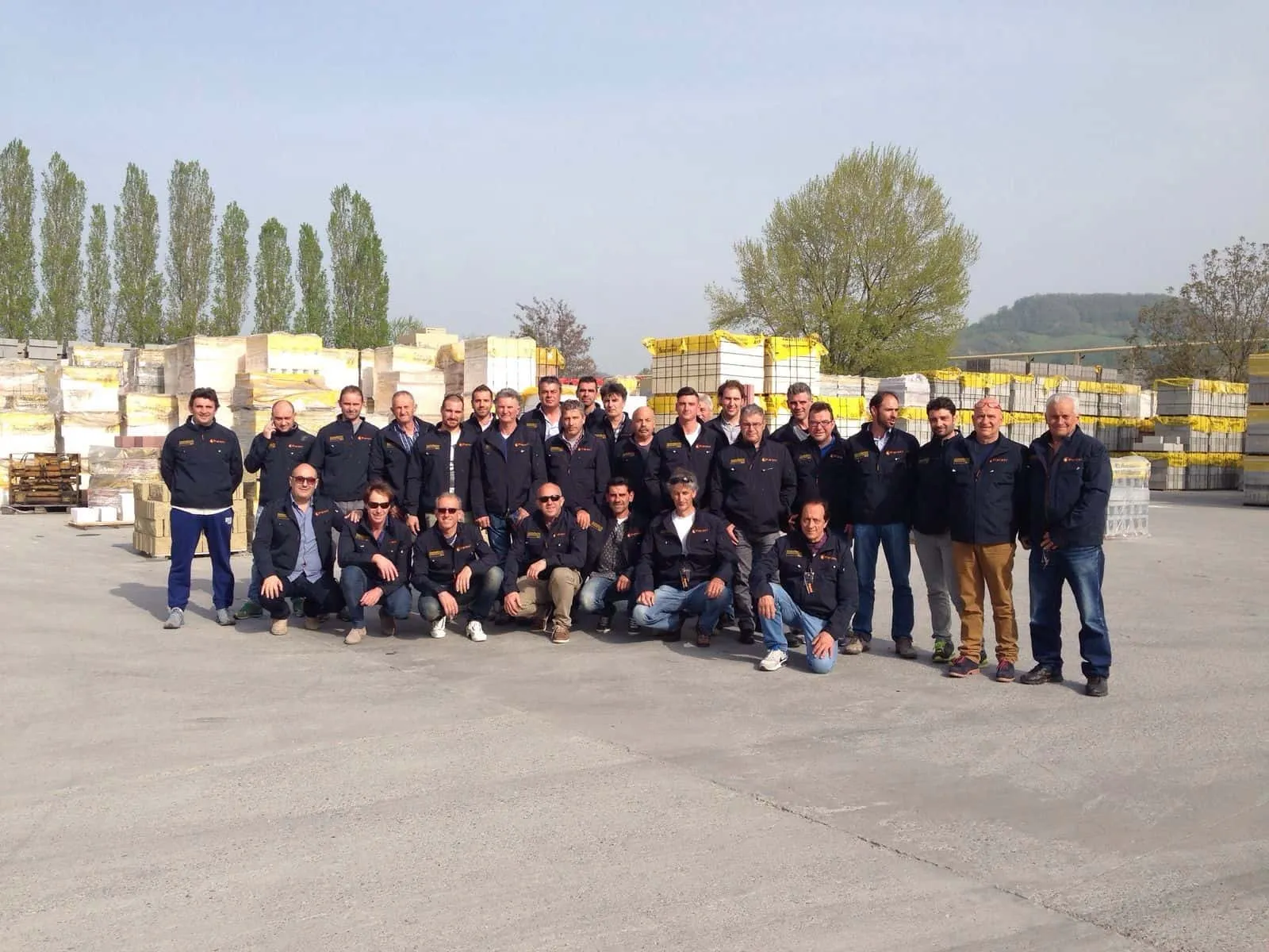 Foto di gruppo dei professionisti clienti Pieroni con elmetti di sicurezza gialli